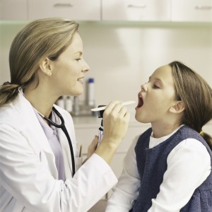an ent examines a patient's mouth